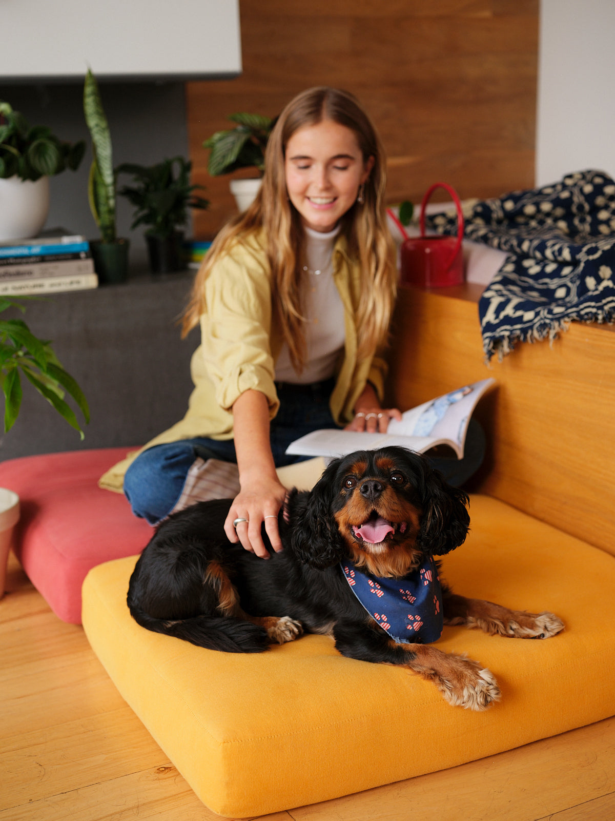 Woman sitting on cushion and petting a dog