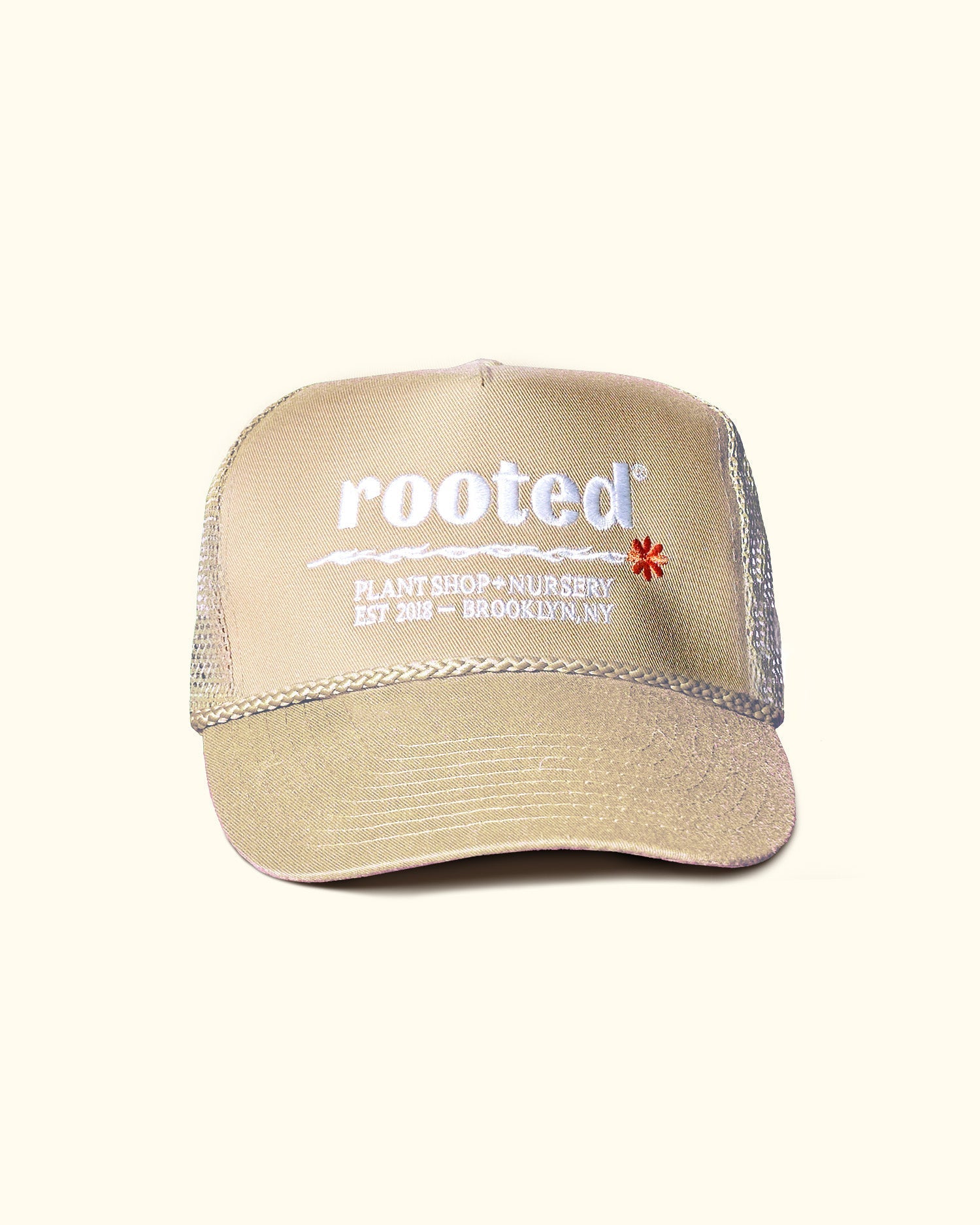 A khaki-colored trucker hat that reads: Rooted Plant shop and nursery. Est. 2018 - Brooklyn, NY